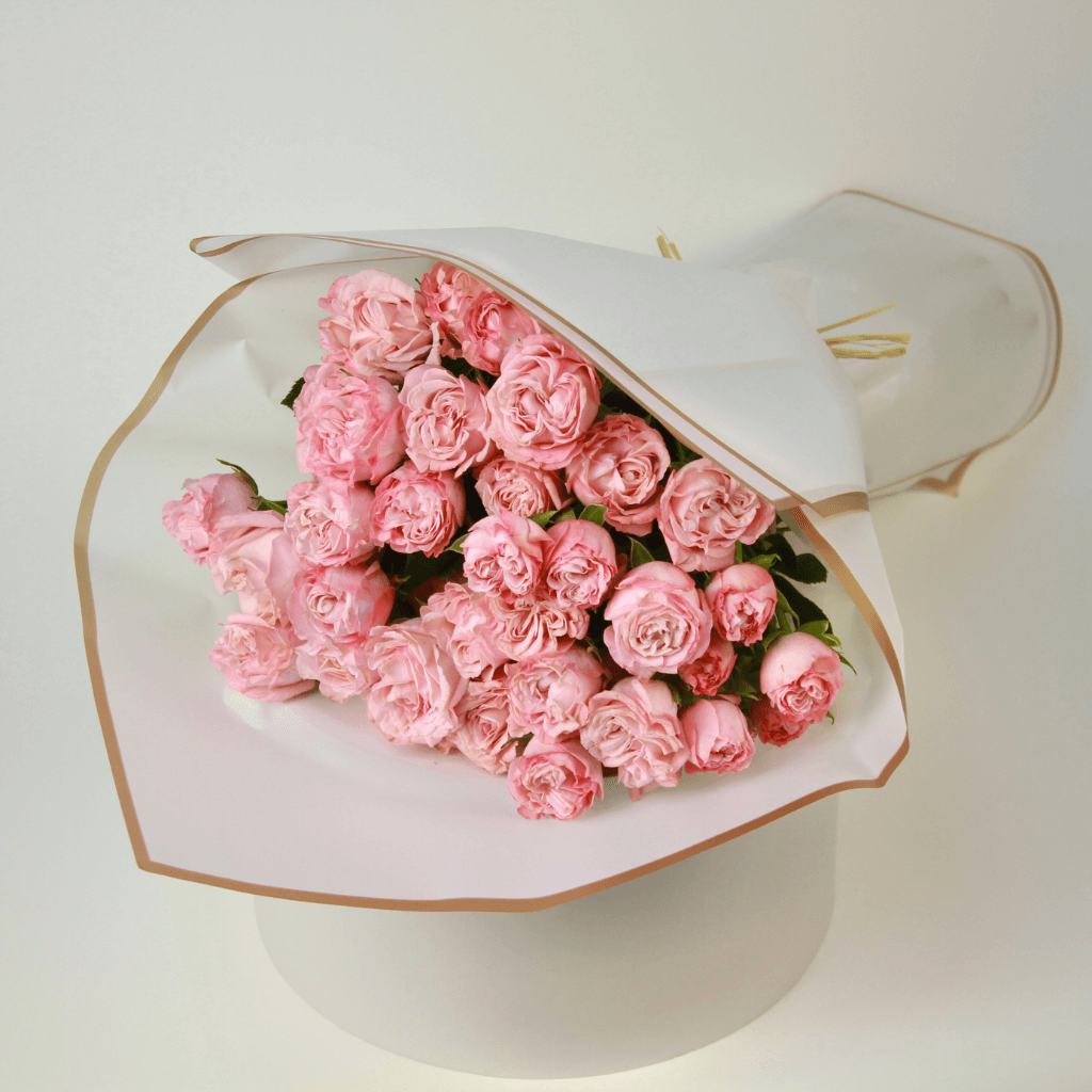 Soft pink spray rose bouquet with delicate clustered blooms arranged for flower delivery in Kuwait