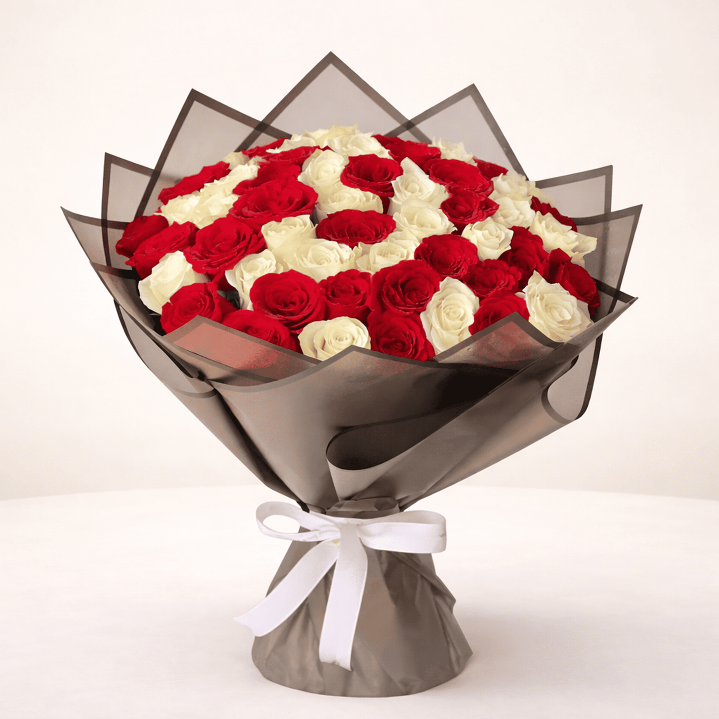 Hand-tied bouquet of 50 red and white roses for flower delivery in Kuwait