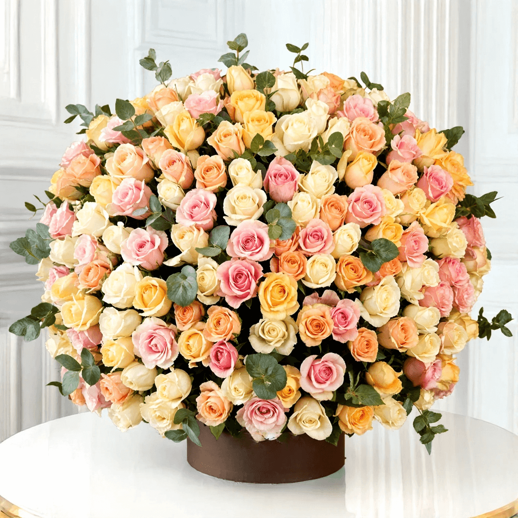 Luxury mixed rose flower box with pastel pink, peach, yellow, and ivory roses for flower delivery in Kuwait