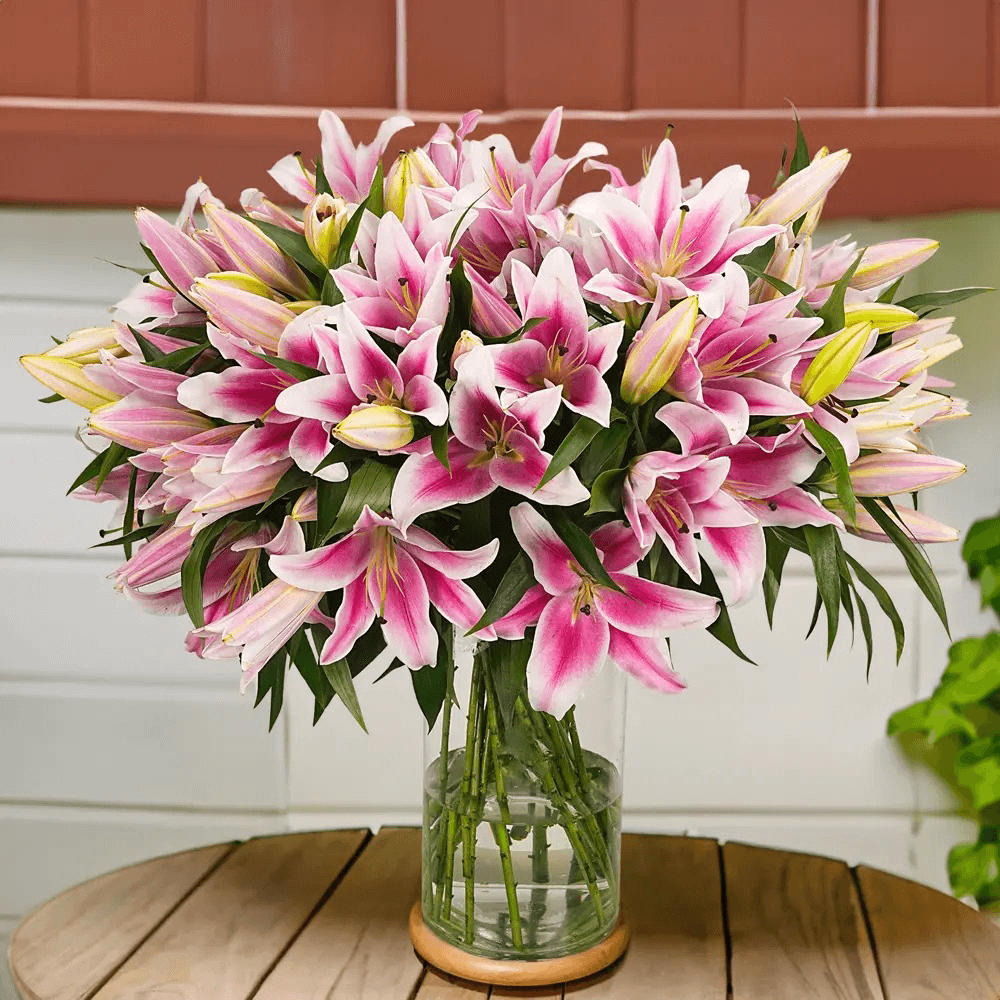 Pink lily flower arrangement in a clear glass vase for flower delivery in Kuwait