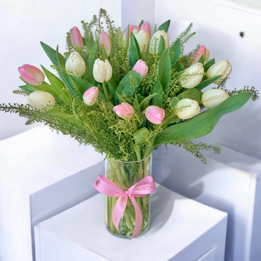 Pink and white tulip in a glass vase arrangement