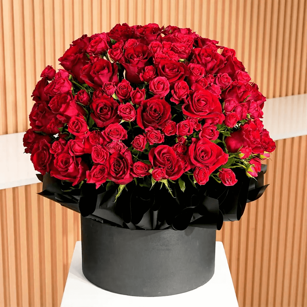 Red rose and spray rose flower hatbox arrangement for flower delivery in Kuwait