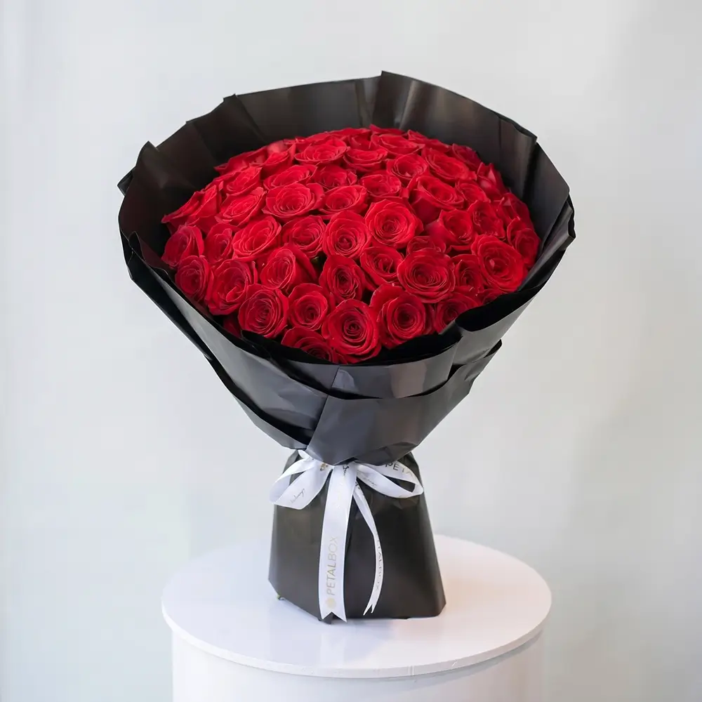 Scarlet Rose Bouquet with 50 fresh red roses wrapped in black paper for flower delivery Kuwait by Buy Flower Box.