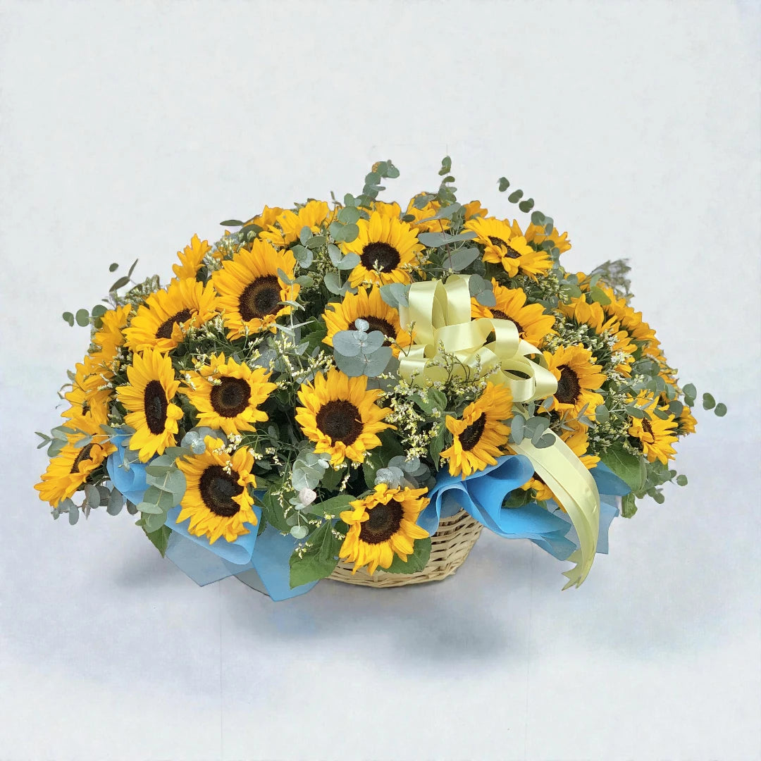 Bouquet of sunflowers with a decorative bow on a light gray background