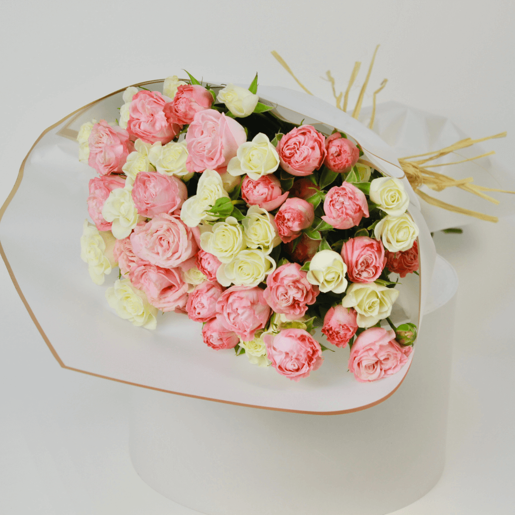 White and pink spray rose bouquet wrapped neatly, perfect for flower delivery in Kuwait