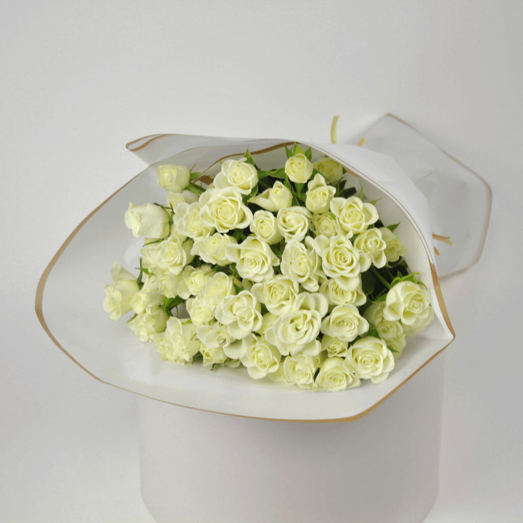 White spray rose bouquet wrapped in soft white paper for elegant flower delivery in Kuwait